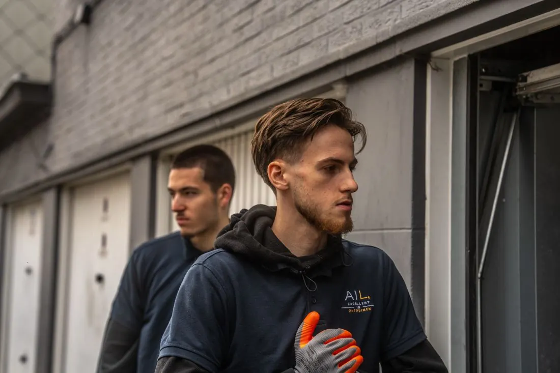 Twee medewerkers van Alles Is Leeg bij een garagebox